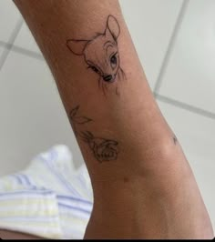 a small dog tattoo on the arm of a person's left leg and wrist