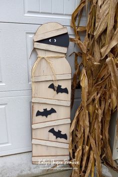 a halloween decoration made out of wooden planks with bats hanging from the top and bottom