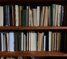 a bookshelf filled with lots of books on top of wooden shelves next to each other