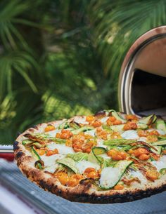 a pizza sitting on top of a pan covered in cheese and veggies