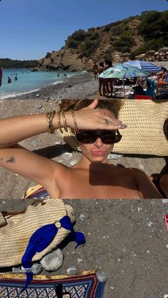 a woman sitting on top of a beach next to the ocean with her hands behind her head