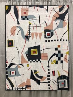 an abstract quilt hanging on the wall