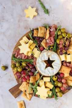 a platter with cheese, crackers and olives