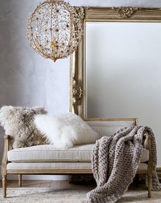 a white couch sitting next to a large mirror