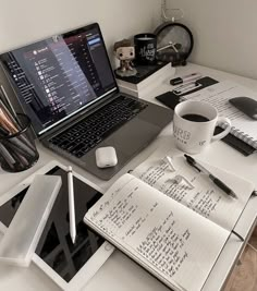 an open laptop computer sitting on top of a desk next to a cup of coffee