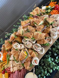 a table filled with lots of sandwiches and veggies on top of each other