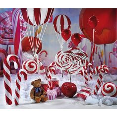 a teddy bear is sitting in front of candy canes and lollipops