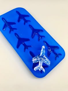 an airplane shaped ice tray is shown with plastic pieces in the shape of small planes