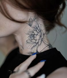 a woman with a flower tattoo on her neck