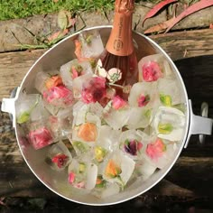 an ice bucket filled with flowers and a bottle of champagne