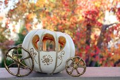 a white pumpkin shaped like a carriage with gold trimmings on the front and sides