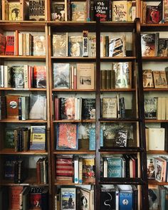 a bookshelf filled with lots of books on top of wooden shelves next to each other