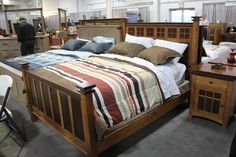 a bed room with a neatly made bed and dressers in it's center