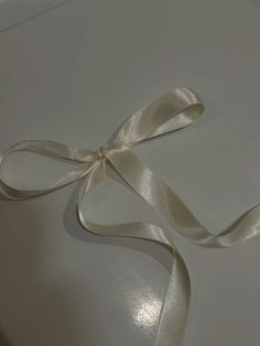 a white box with a satin ribbon on it's side and the lid open