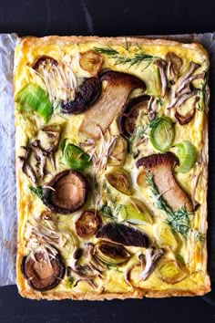 an artichoke quiche with mushrooms, onions and green peppers on a piece of parchment paper