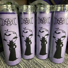 three purple tumbles with the silhouettes of witches and moon symbols on them, sitting next to each other