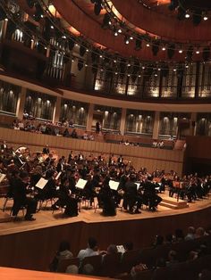 an orchestra performing on stage with lots of people