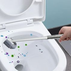 a person cleaning a toilet with a brush