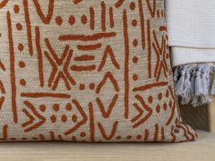 an orange and white pillow sitting on top of a wooden table