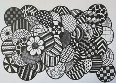 a black and white drawing of many different designs on the wall, with one large flower in the center