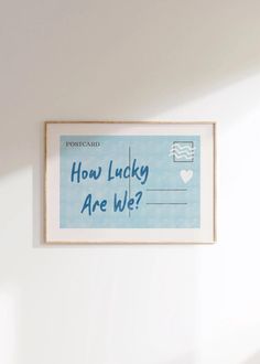 a sign hanging on the wall that says how lucky are we? in blue and white