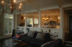 a living room filled with furniture and a chandelier hanging over the top of it