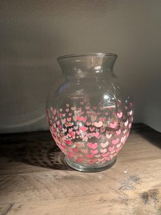 a glass vase with hearts painted on it