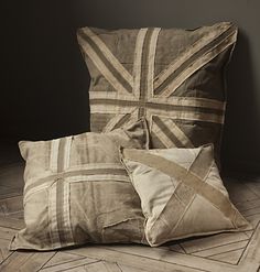 two pillows sitting next to each other on top of a wooden floor in front of a wall