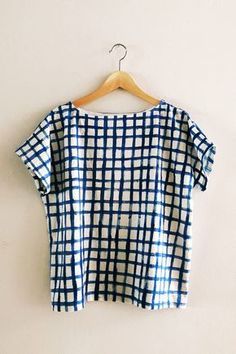 a blue and white checkered shirt hanging on a hanger