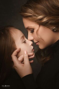 two young women are touching each other's face with their hands and noses together