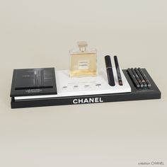 a chanel perfume and other items are displayed on a black box with white writing