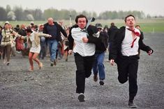 two men running in the middle of a group of people