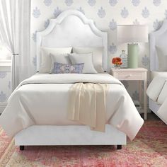 two beds in a bedroom with blue headboards