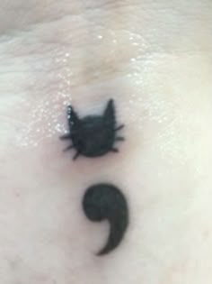 a small black cat on the side of a woman's stomach with an upside down tail