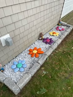 the flower garden is made out of rocks and gravel, along with small toys in it