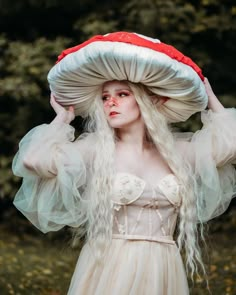 a woman with long white hair wearing a large mushroom hat on her head and dress