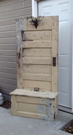 an old wooden door sitting on top of a cement block next to a white building