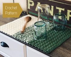 crochet placemats and glass jars on a table with a wooden spoon