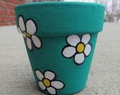 a painted flower pot sitting on the ground