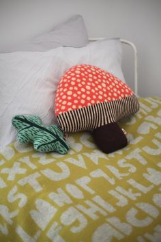 two stuffed animals sitting on top of a bed next to pillows and pillowcases