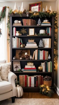 a book shelf filled with lots of books next to a white chair and christmas decorations