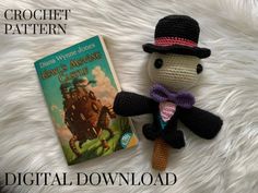 a crochet doll and book sitting on top of a white blanket