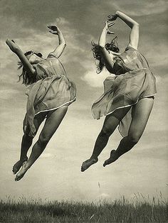 two women are jumping in the air with their arms up and legs spread wide open