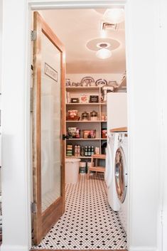 a washer and dryer sitting in a room next to a doorway that leads into a kitchen