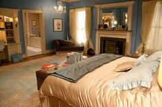 a bedroom with blue walls and a fireplace