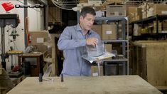 a man is working in a shop with boxes and other items on the shelves behind him