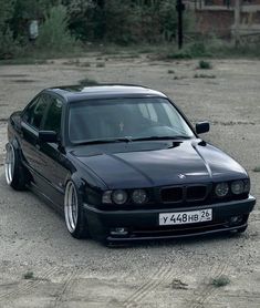 a black car parked on top of a dirt field