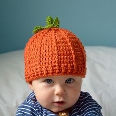 a baby wearing an orange knitted hat