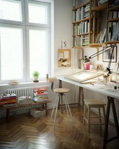 a room with a desk, bookshelf and two chairs next to each other