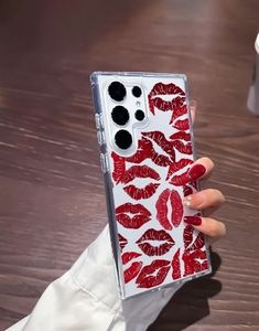 a woman holding up her phone case with red lipstick prints on the front and sides